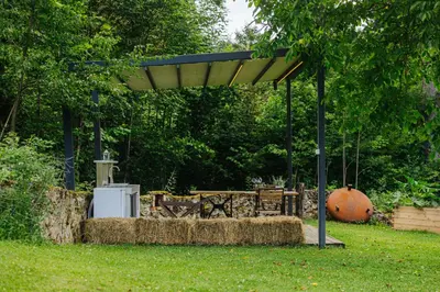 a pavilion with hay bales in a garden at GOZDNE VILE va VRTI in Kostel