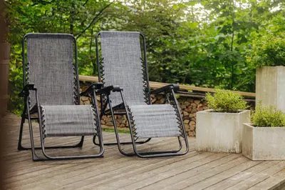 two mesh chairs sitting on top of a deck at GOZDNE VILE va VRTI in Kostel