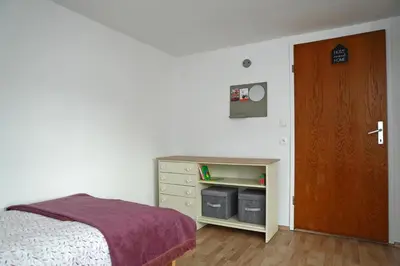 a bedroom with a bed next to a wooden door at House Minka in Ptuj