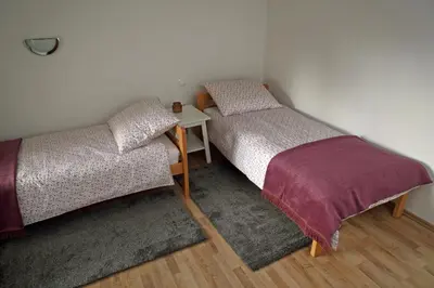 two twin beds in a room with a table at House Minka in Ptuj