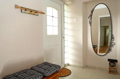 a mirror and a ottoman in front of a door at House Minka in Ptuj