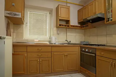 a kitchen with wooden cabinets and a sink and a window at House Minka in Ptuj