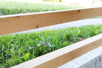 a wooden fence with flowers in the grass at Glamping - Hayrack Vesel in Trebnje