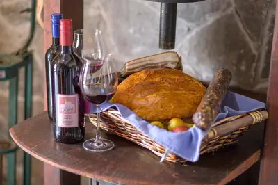 a basket of bread and two wine glasses on a table at Glamping - Hayrack Vesel in Trebnje