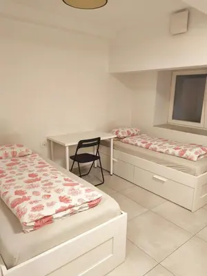 a room with two beds and a desk and a chair at Studio Ljubljana in Ljubljana