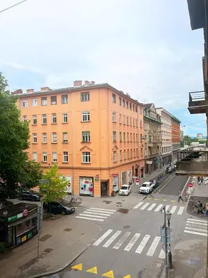 an empty city street with a large orange building at Studio Ljubljana in Ljubljana