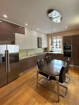 a kitchen with a table with chairs and a refrigerator at Apartment Ljubljana in Ljubljana
