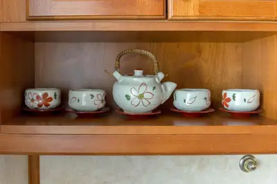 a shelf with a teapot and four cups on it at Apartment Franko in Radovljica