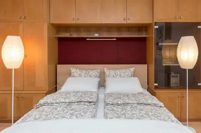 a bedroom with a bed with two pillows and two lamps at Apartment Franko in Radovljica