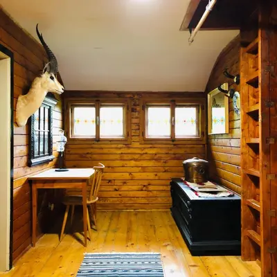 a room with a desk and a table in a cabin at Red Beech Cabin - An Alpine Cabin near Lake Bohinj in Bohinj