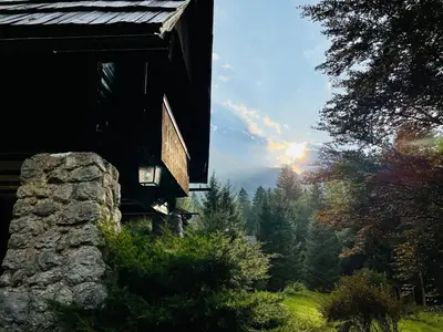a view from the outside of a cabin with a view of the forest at Red Beech Cabin - An Alpine Cabin near Lake Bohinj in Bohinj