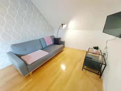 a living room with a blue couch and a table at Villa Nebina in Rateče