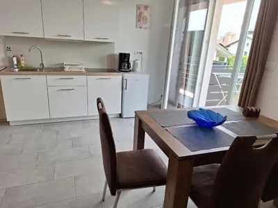 a kitchen with a wooden table with chairs and a sink at Apartments Rosemary Ljubljana & Free Parking in Ljubljana