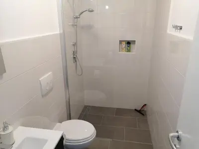 a bathroom with a shower with a toilet and a sink at Apartments Rosemary Ljubljana & Free Parking in Ljubljana