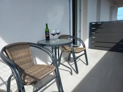 a table with two chairs and a bottle and wine glasses at Apartments Rosemary Ljubljana & Free Parking in Ljubljana