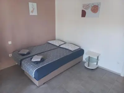 a small bedroom with a bed and a stool at Apartments Rosemary Ljubljana & Free Parking in Ljubljana