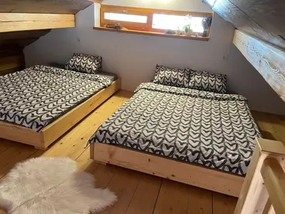 a bedroom with two beds and a rug at Vineyard cottage Stopar in Straža