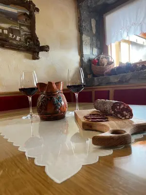 a table with two glasses of red wine and bread at Vineyard cottage Stopar in Straža
