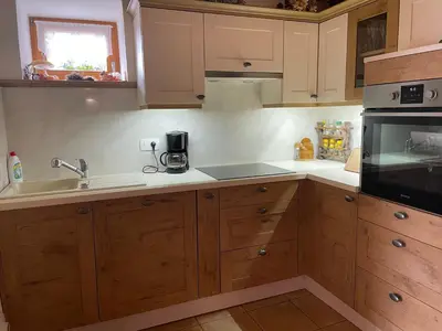 a kitchen with wooden cabinets and a sink at Vineyard cottage Stopar in Straža