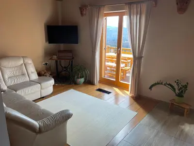 a living room with a couch and a sliding glass door at Vineyard cottage Stopar in Straža