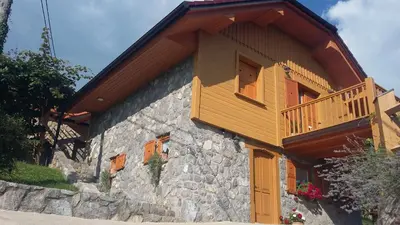 a building with a balcony on the side of it at Vineyard cottage Stopar in Straža