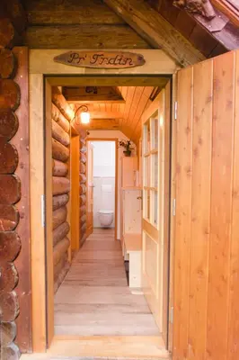 a hallway leading to a bathroom in a log house at Wood house Irena-Počitniška hiša in Bohinj