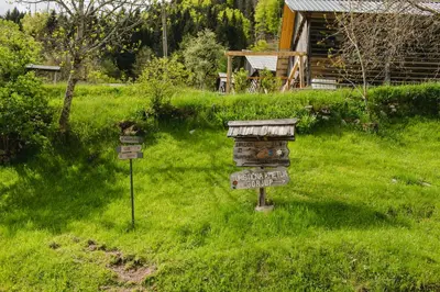 a sign in the middle of a grass field at Wood house Irena-Počitniška hiša in Bohinj