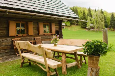 a wooden table and chairs in front of a cabin at Wood house Irena-Počitniška hiša in Bohinj