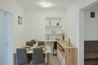 a kitchen and dining room with a table and chairs at Apartments Pr' Štormanu in Kanal