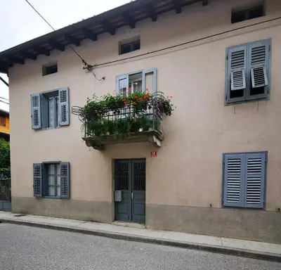 a building with a balcony with flowers on it at Apartments Pr' Štormanu in Kanal