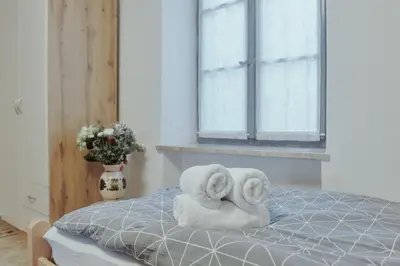 two towels sitting on a bed with a window at Apartments Pr' Štormanu in Kanal