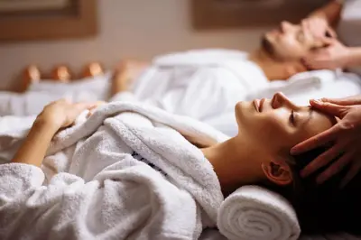 a man and a woman laying in bed under a towel at Zlata Ladjica Boutique Hotel in Ljubljana
