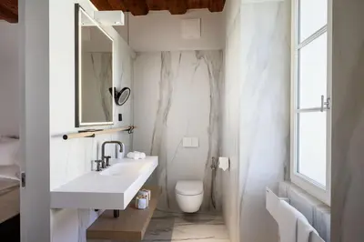 a white bathroom with a sink and a toilet at Zlata Ladjica Boutique Hotel in Ljubljana