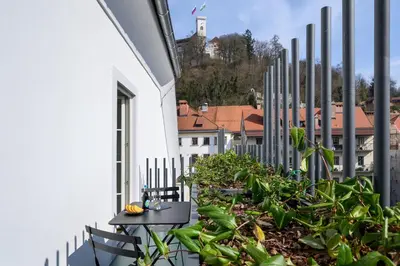 a balcony with chairs and plants on a building at Zlata Ladjica Boutique Hotel in Ljubljana