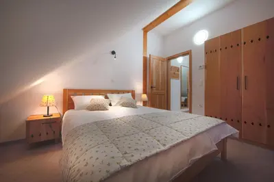 a bedroom with a large bed with a wooden headboard at Wine & Tourism Bračko in Jakobski Dol