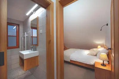 a bathroom with a bed and a sink and a mirror at Wine & Tourism Bračko in Jakobski Dol