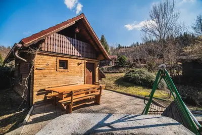 a wooden cabin with a picnic table in front of it at Wooden Cabin Zurej with Hot Tub in Bukovje v Babni Gori