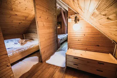 a small room with a bed and a mirror at Wooden Cabin Zurej with Hot Tub in Bukovje v Babni Gori