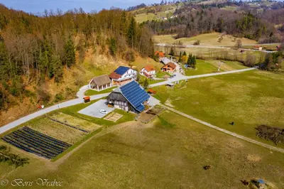 an aerial view of a house on a green field at Wooden Cabin Zurej with Hot Tub in Bukovje v Babni Gori