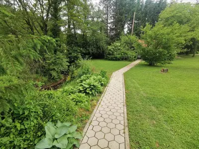 a garden with a walkway in the grass at Wooden Cabin Zurej with Hot Tub in Bukovje v Babni Gori