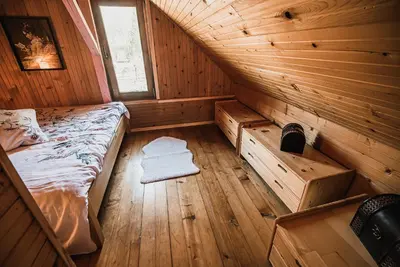 a bedroom with a bed in a wooden cabin at Wooden Cabin Zurej with Hot Tub in Bukovje v Babni Gori