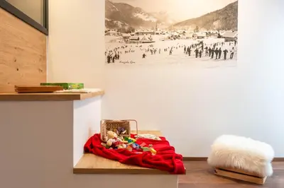 a room with a red blanket and toys on a table at HIŠA KOSOBRIN in Kranjska Gora