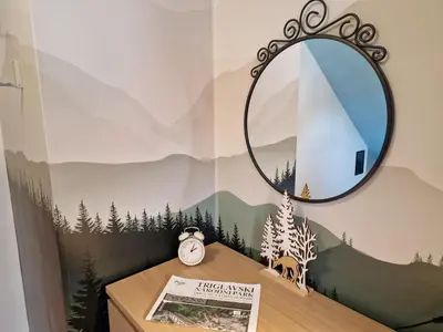 a mirror on top of a table with a clock at 7 LAKES apartment in Bohinj