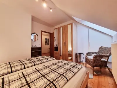 a bedroom with a bed and a chair at 7 LAKES apartment in Bohinj