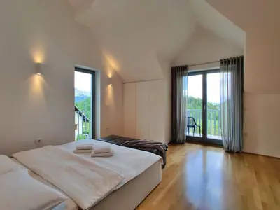 a bedroom with two beds and a large window at Villa Recica North in Bled