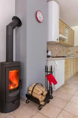 a kitchen with a wood stove in a room at Peaceful Rogla Apartment in Zreče