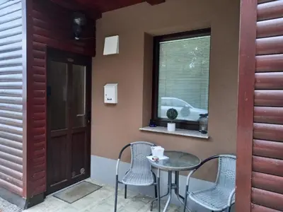 a patio with a table and chairs and a window at Peaceful Rogla Apartment in Zreče