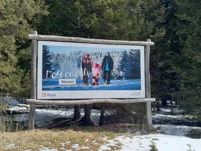 a sign with three people on it in the snow at Peaceful Rogla Apartment in Zreče