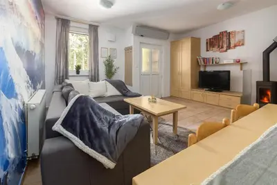 a living room with a couch and a tv at Peaceful Rogla Apartment in Zreče