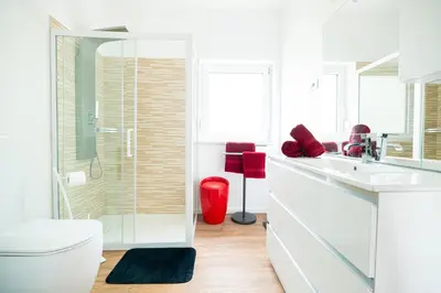 a white bathroom with a toilet and a glass shower at Hiša Kragelj in Most na Soči